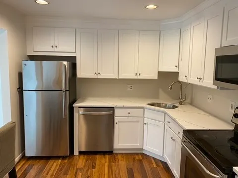 a kitchen with a refrigerator sink and cabinets