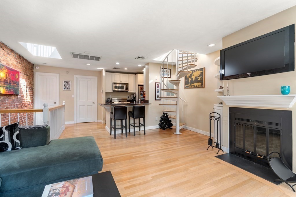 231 West Canton Street, Unit 4 Boston, MA 02116 - Photo 6 of 17 a living room with furniture a flat screen tv and a fireplace