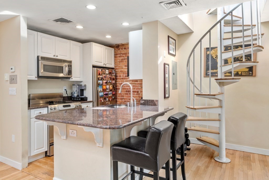 231 West Canton Street, Unit 4 Boston, MA 02116 - Photo 8 of 17 a kitchen with kitchen island a appliances dining table and chairs