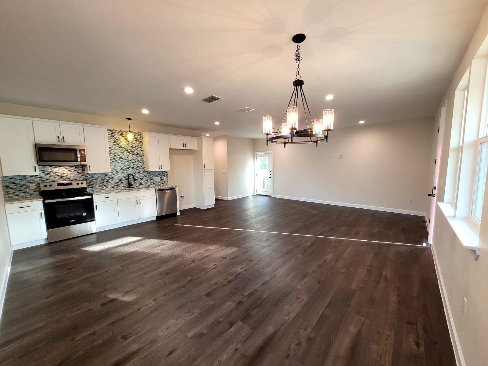 750 South Main Street Lockhart, TX 78644 - Photo 6 of 31 Unfurnished dining area featuring dark wood-style flooring and hanging lights