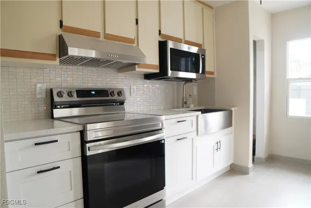 a kitchen with stainless steel appliances a stove microwave and cabinets
