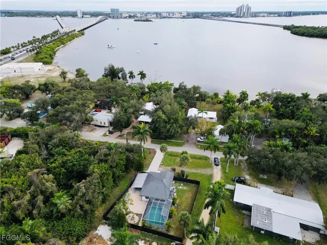 an aerial view of a house with a yard and lake view