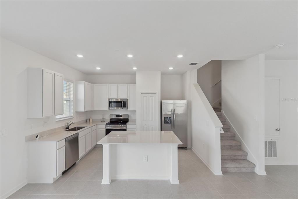 2653 Skyline Loop Kissimmee, FL 34758 - Photo 13 of 42 a kitchen with white cabinets and stainless steel appliances