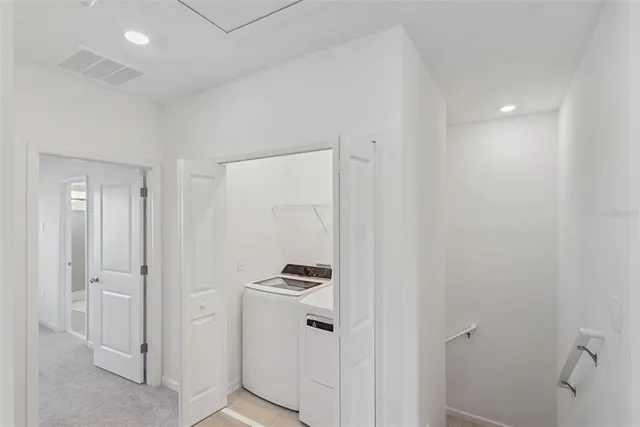 a walk in closet with white cabinets
