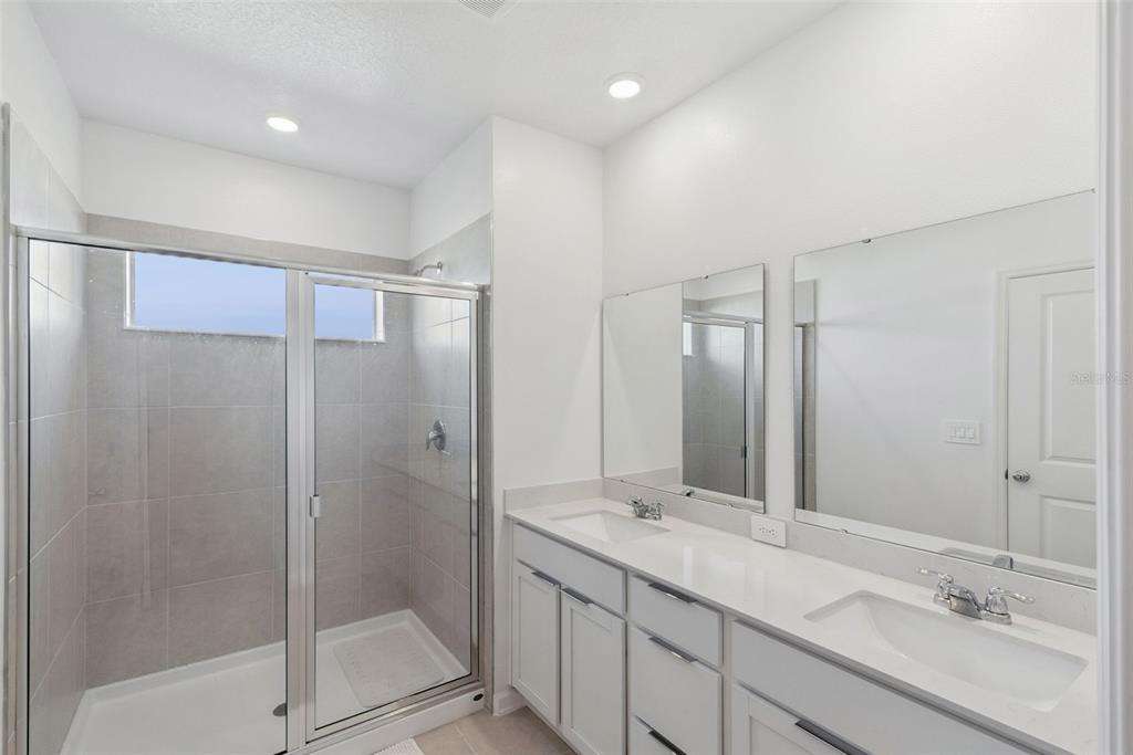 2653 Skyline Loop Kissimmee, FL 34758 - Photo 19 of 42 a bathroom with a shower sink and mirror