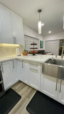 a kitchen with stainless steel appliances a sink a stove and cabinets
