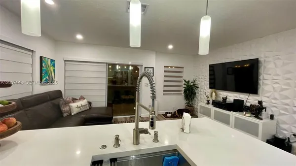 a kitchen with kitchen island granite countertop a stove and a sink