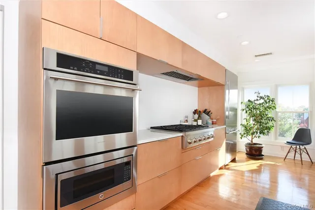 a kitchen with granite countertop stainless steel appliances and wooden floor