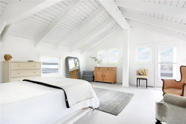 a bedroom with a bed couch and a large window