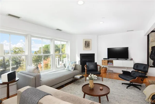 a living room with furniture a flat screen tv and a large window