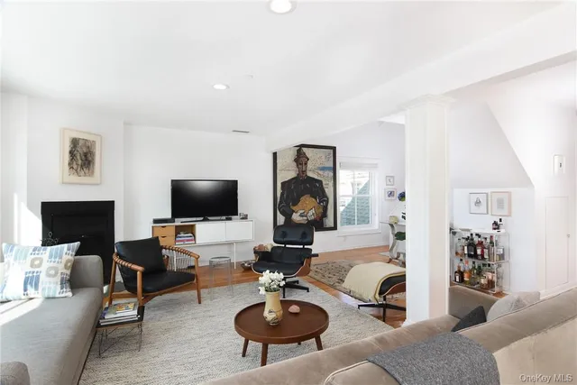 a living room with furniture a flat screen tv and a fireplace