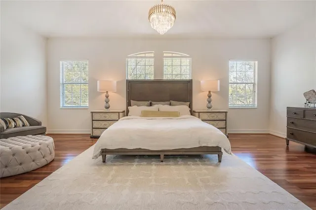 a spacious bedroom with a bed and a chandelier