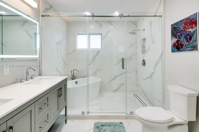 a bathroom with a sink a toilet and shower