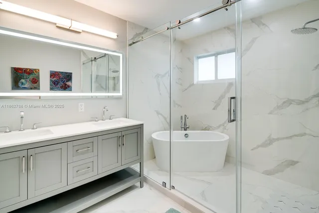 a spacious bathroom with a double vanity sink mirror and bathtub