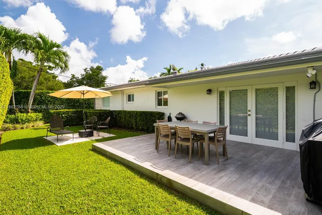 a view of a patio with table and chairs floor to ceiling window and yard