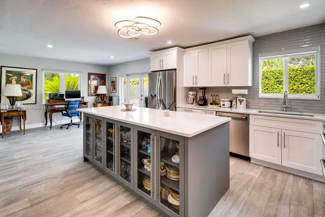 a kitchen with stainless steel appliances a sink stove cabinets and wooden floor