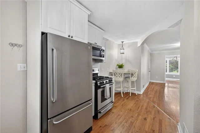 a kitchen with stainless steel appliances a refrigerator and a stove top oven