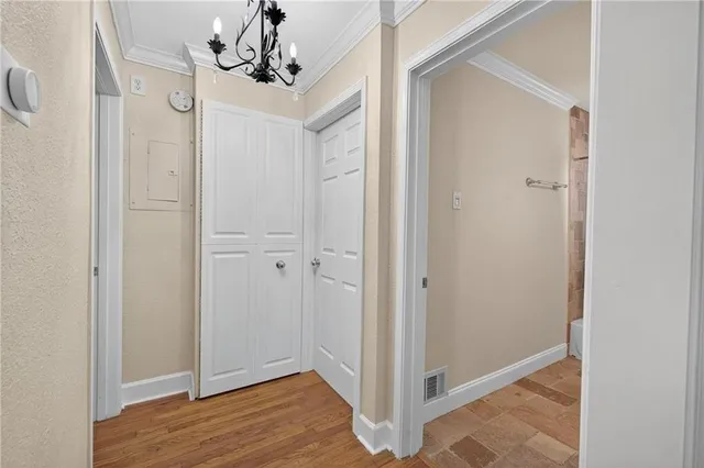a view of a chandelier in hallway with wooden floor