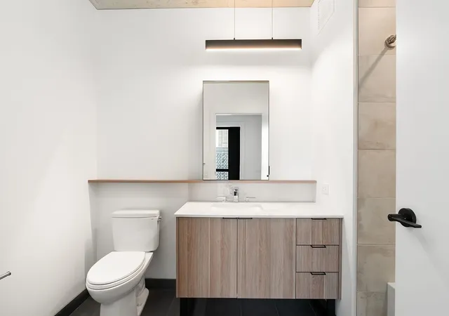 a bathroom with a toilet sink and mirror