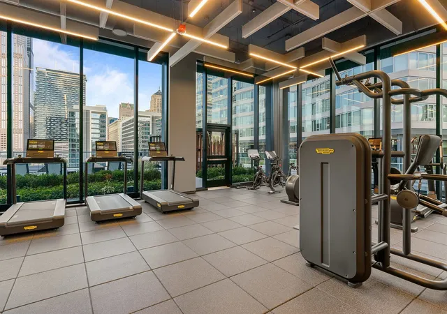a room with gym equipment and large windows
