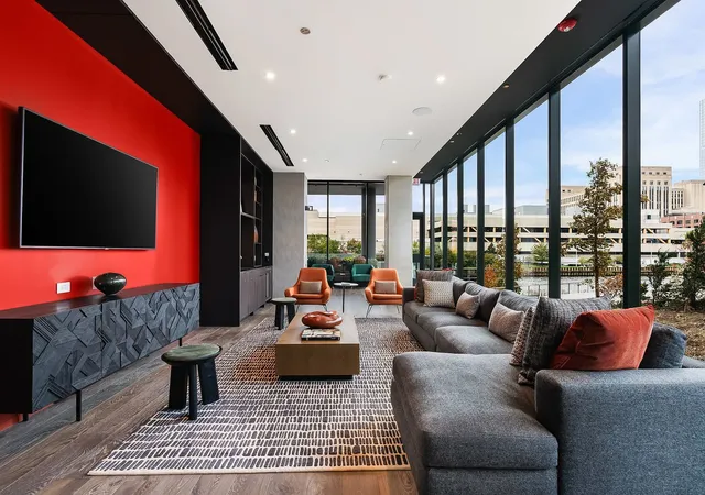 a living room with furniture a flat screen tv and a floor to ceiling window