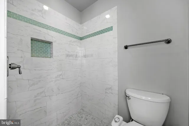 a bathroom with a toilet and a shower