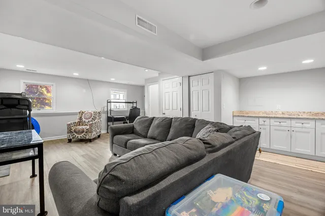 a living room with furniture window and kitchen view