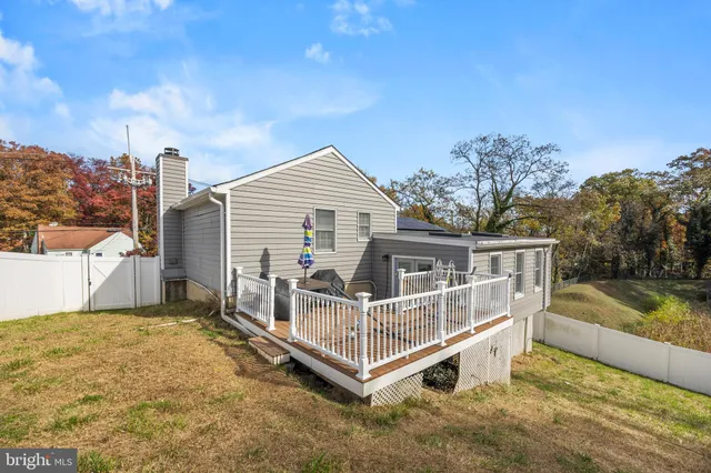a white house that has a small yard and wooden fence