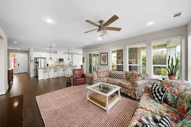 a kitchen with stainless steel appliances a dining table chairs stove refrigerator and cabinets