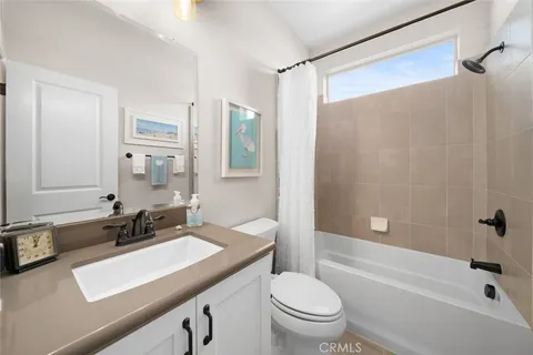 a view of a white house with a yard and potted plants