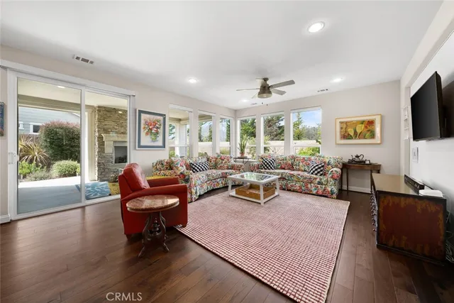 a living room with furniture a flat screen tv and a large window