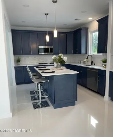 a kitchen with stainless steel appliances granite countertop a stove a sink dishwasher a refrigerator and a oven with wooden floor