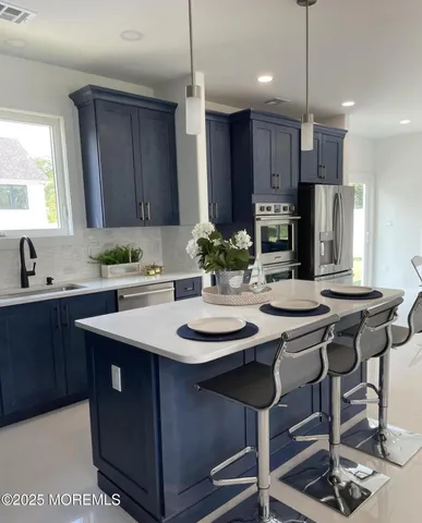 a kitchen with kitchen island granite countertop a sink and a refrigerator