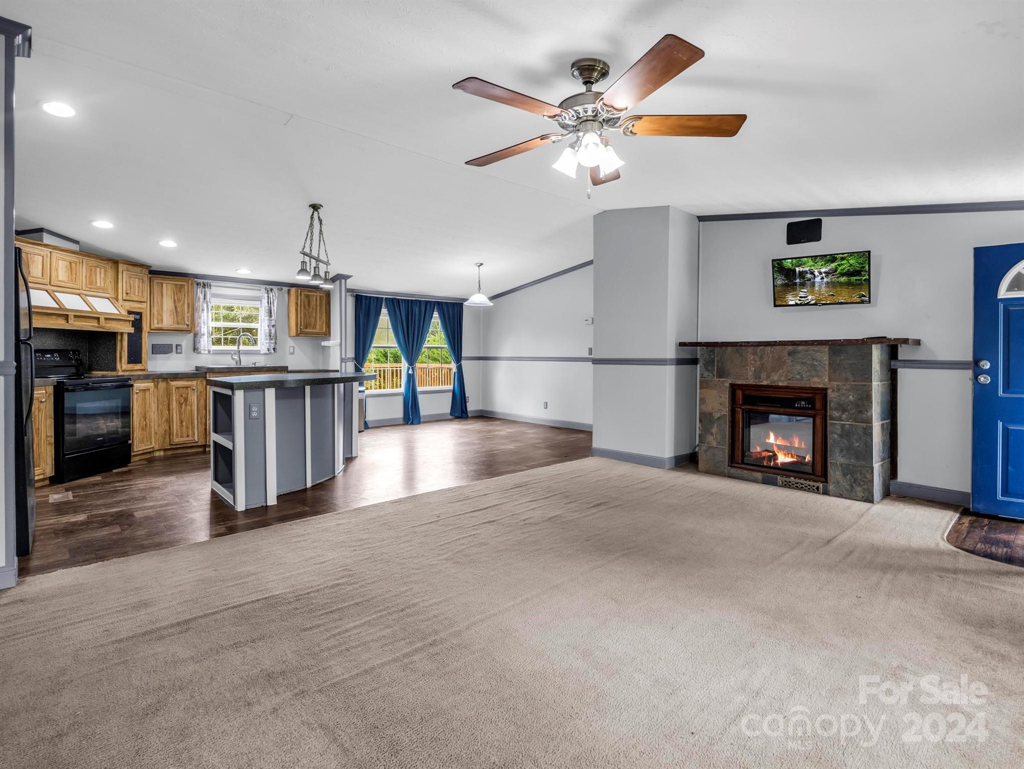 246 Abrams Moore Road Rutherfordton, NC 28139 - Photo 11 of 46 a view of a kitchen with a sink a fireplace a refrigerator and a ceiling fan