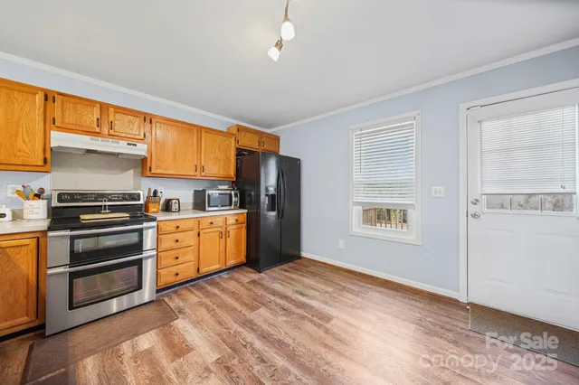 a kitchen with granite countertop a refrigerator and cabinets