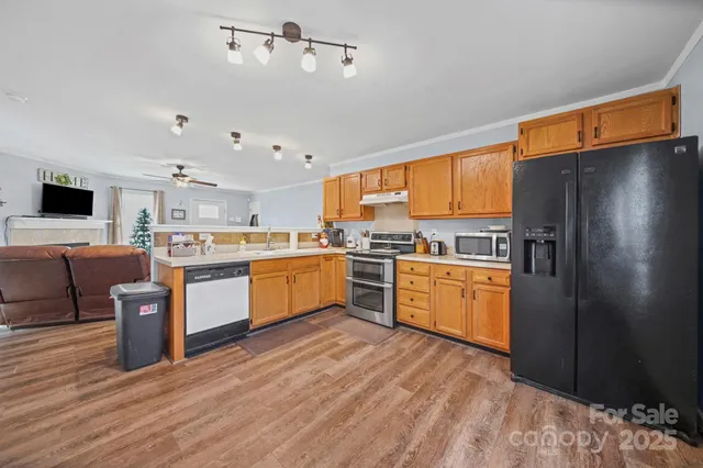 a kitchen with stainless steel appliances a refrigerator a sink dishwasher stove and oven