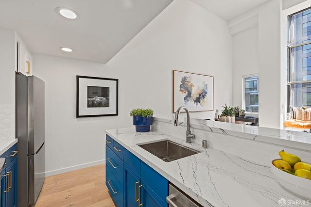 a kitchen with stainless steel appliances granite countertop a sink a stove and a refrigerator