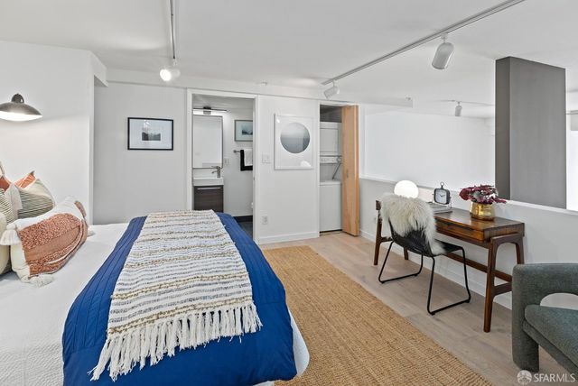 a bedroom with a bed and wooden floor