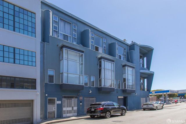 a front view of a building with lot of cars