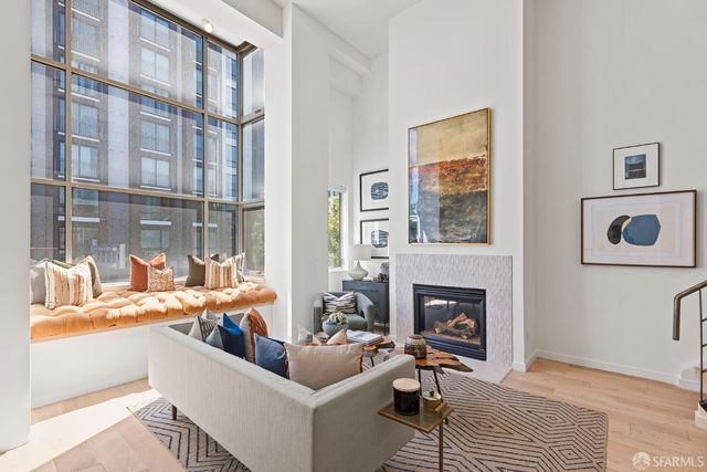 a living room with furniture a fireplace and a floor to ceiling window
