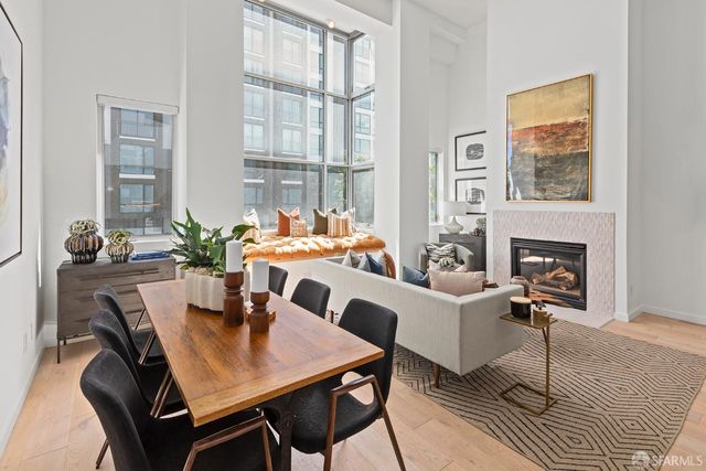 a dining room with furniture a fireplace and wooden floor