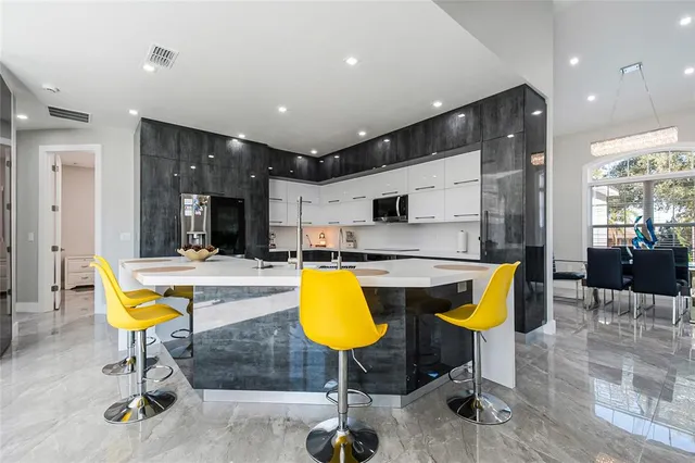 a swimming pool with a table chairs and glass door