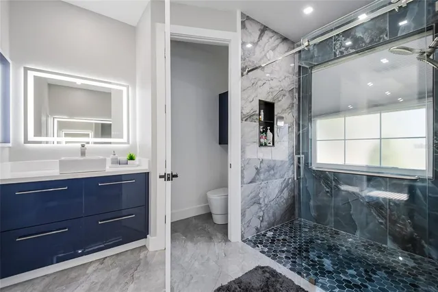 a bathroom with a sink a mirror and a shower