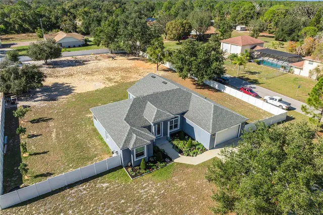 an aerial view of a house with a yard and lake view