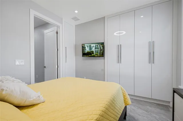 a bedroom with a bed and a flat screen tv