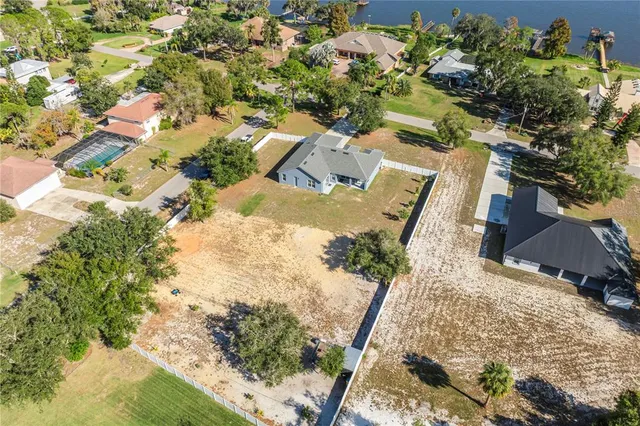 an aerial view of residential houses with outdoor space and trees