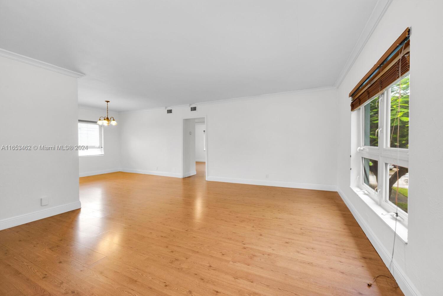 5630 Southwest 76th Street, Unit 3 Miami, FL 33143 - Photo 4 of 16 a view of an empty room with window and wooden floor