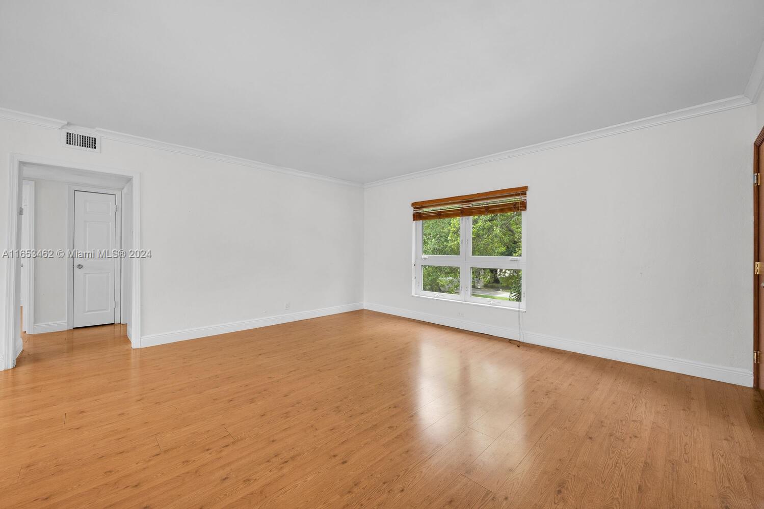 5630 Southwest 76th Street, Unit 3 Miami, FL 33143 - Photo 5 of 16 a view of an empty room with wooden floor and a window