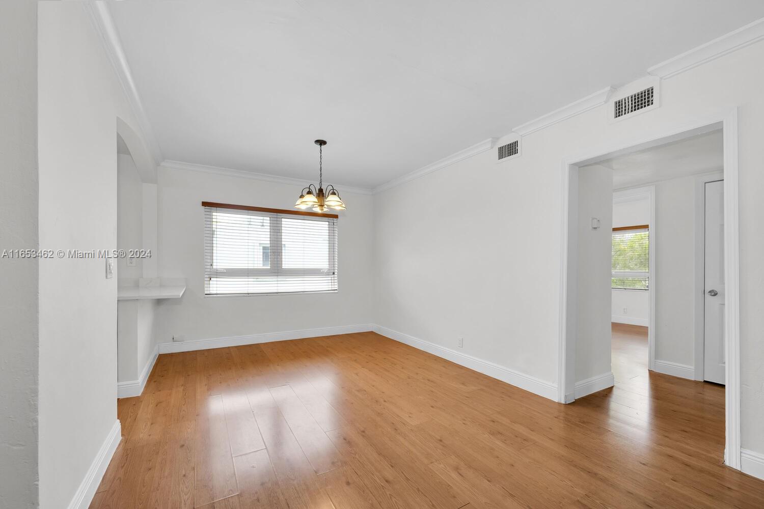 5630 Southwest 76th Street, Unit 3 Miami, FL 33143 - Photo 6 of 16 an empty room with wooden floor and windows