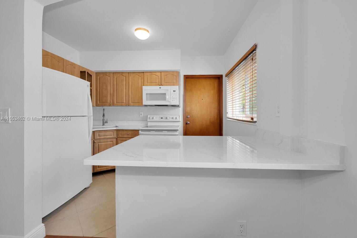 5630 Southwest 76th Street, Unit 3 Miami, FL 33143 - Photo 9 of 16 a view of kitchen with white cabinets
